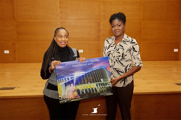 Photo 7: An executive member of staff presents the Honourable Michelle Benjamin, Minister of Culture and Community Development with artwork of the Southern Academy for the Performing Arts as a token of appreciation for her Ministerial tour.